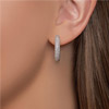 Diamond hoop earrings worn on left ear